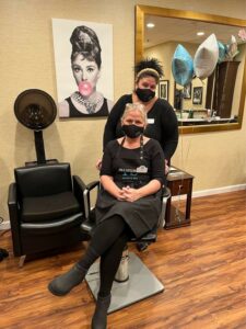 client having hair done in salon chair