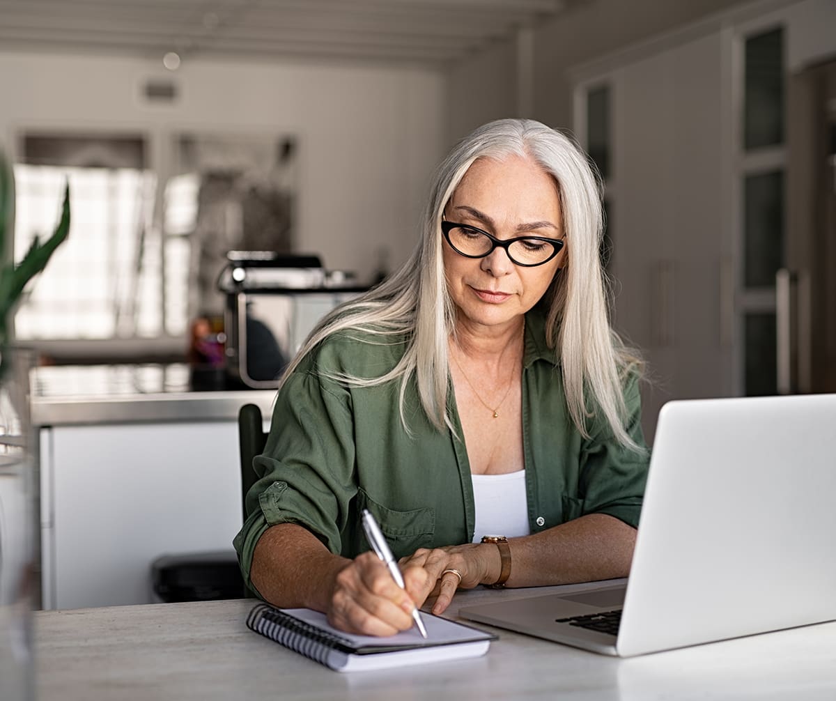 Older woman writing on a pad