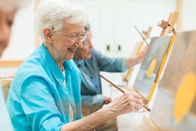 Senior woman painting at StoneRidge Senior Living Community in Mystic, CT
