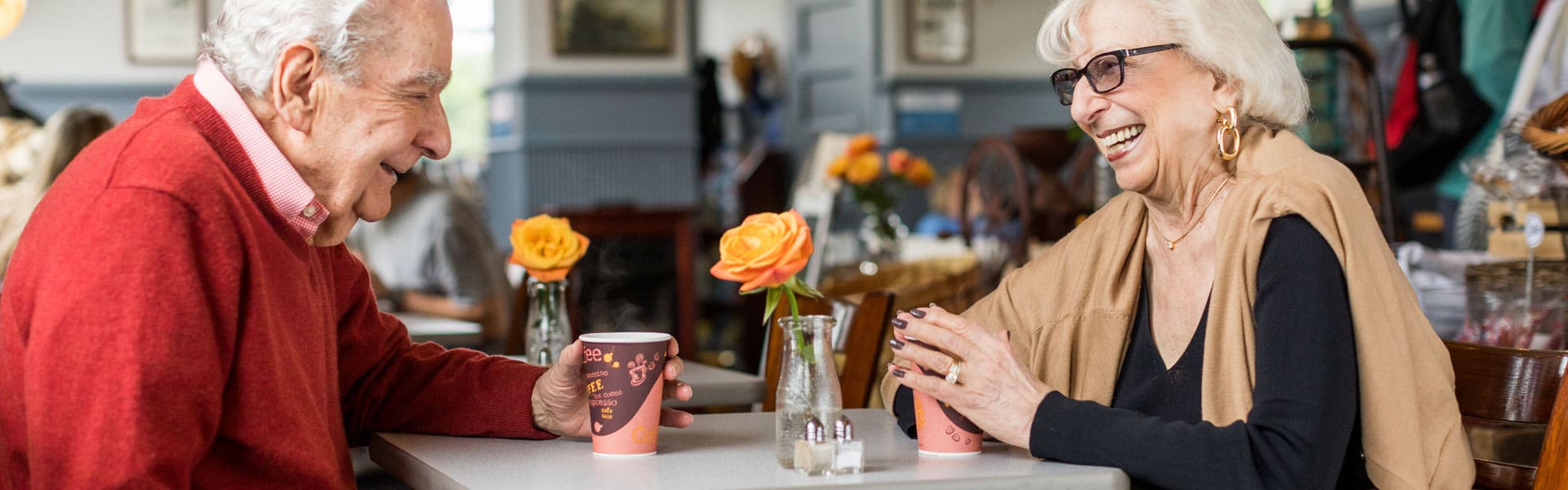 Senior couple laughing and drinking coffee together