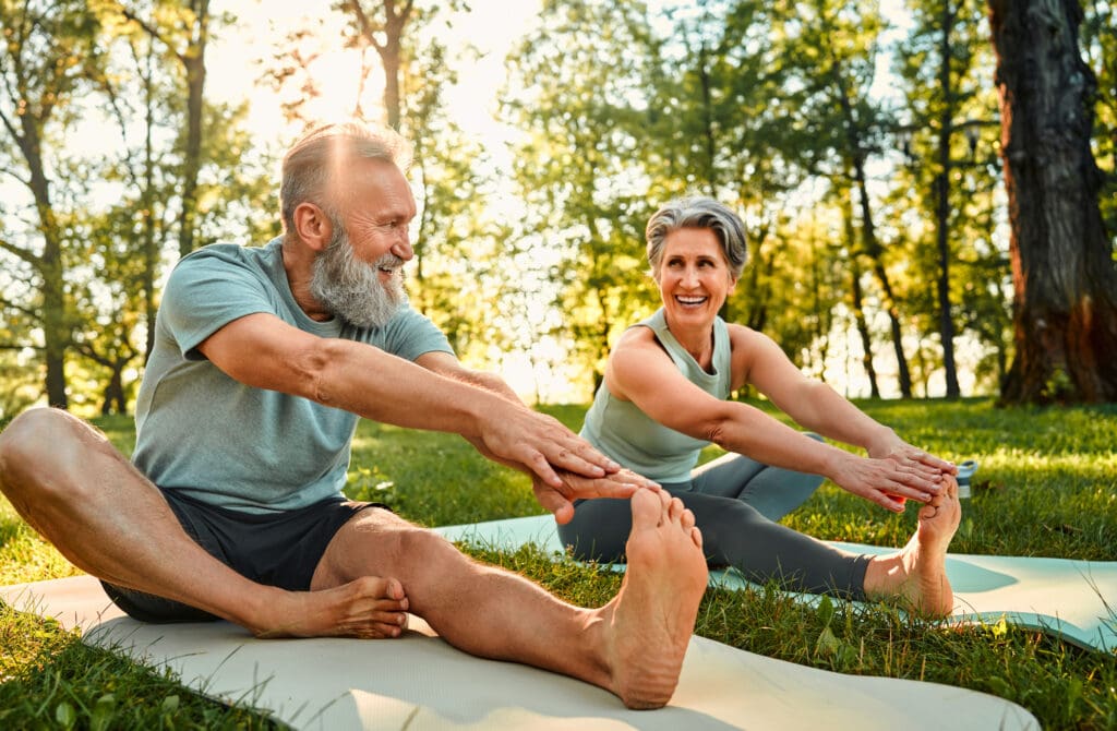 An elderly couple practicing and discovering the benefits of yoga for seniors at StoneRidge in Mystic, Connecticut.